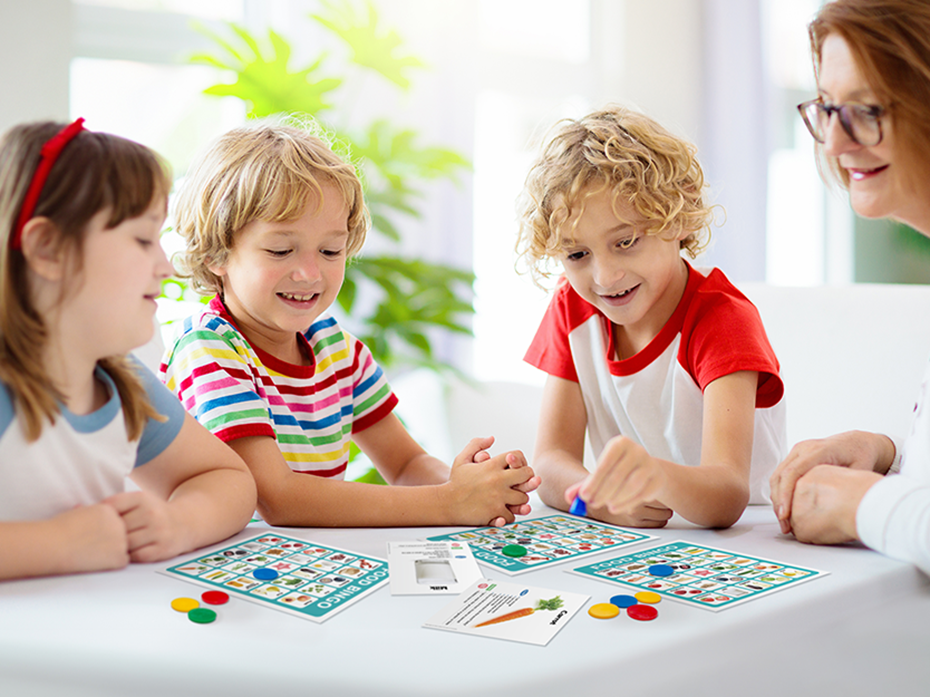 Une femme qui joue au bingo avec 3 enfants assis à une table